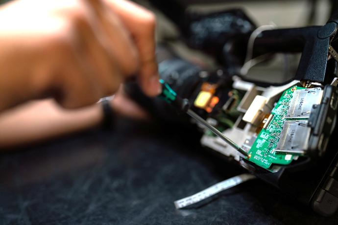 person holding green and black circuit board